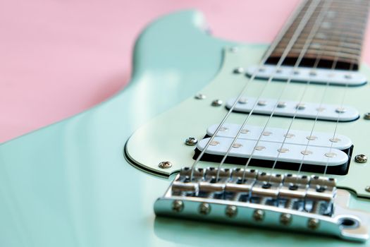 Detail of Mint Green Electric Guitar on a Pink background.