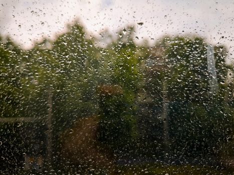 Dirty window full of water drops at rainy weather