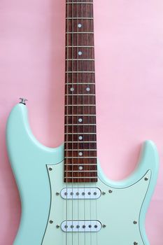 Detail of Mint Green Electric Guitar on a Pink background.