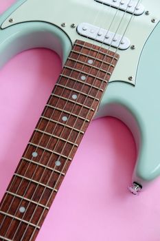 Detail of Mint Green Electric Guitar on a Pink background.