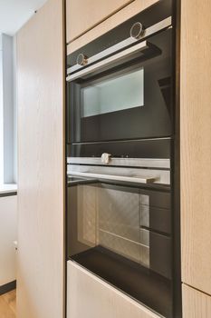 Multi-storey and modern cooker with black appearence and tall shelf near