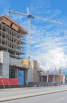 Concrete high rise residential building under constraction on blue sky background