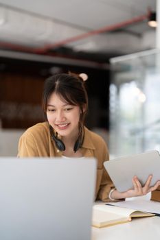 Portrait of young asian woman using laptop working or learning on laptop indoors- educational course or training, seminar, education online concept