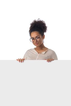 Cheerful black woman holding white blank banner with copy space isolated on white background