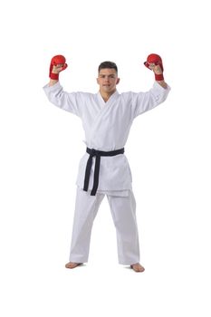 Full length portrait of a fighter man winner in karate kimono holding isolated on white background