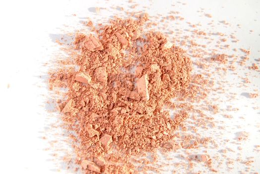 Scattered crumbs of face powder or eye shadow, makeup concept.