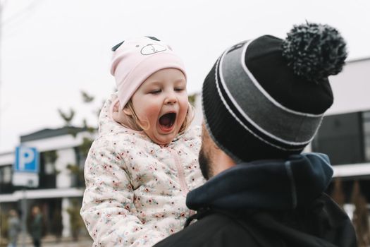 Happy emotional girl with father. Family having fun outdoors. Father and daughter together.