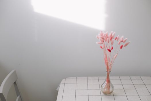Still life of pink dry lagurus flowers on white background with copy space.