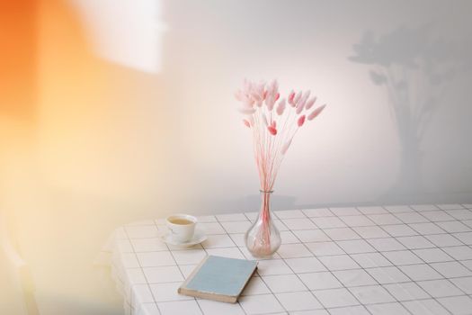 modern interior design in contemporary and cozy living room with dry plants in vase, book and tea cup on the table