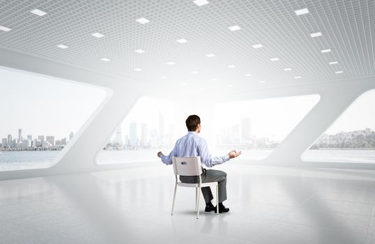 young businessman in the office meditates, achieve calmness, to achieve the goal