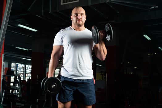 Male bodybuilder engaged with dumbbells in the gym. Healthy lifestyle