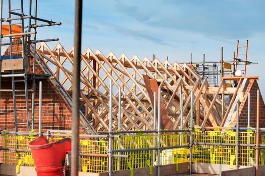 Roof erection is in progress. Trusses installed on top of new house