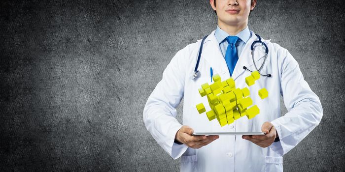 Confident and professional doctor in medical uniform presenting set of multiple cubes above tablet