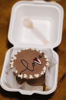 Bento cake with inscription love and white sugar hearts in plastic box-packaging.