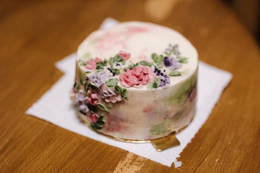 Small bento cake decorated by sugar flowers as a gift for the holiday. Cakes in a box for one person.