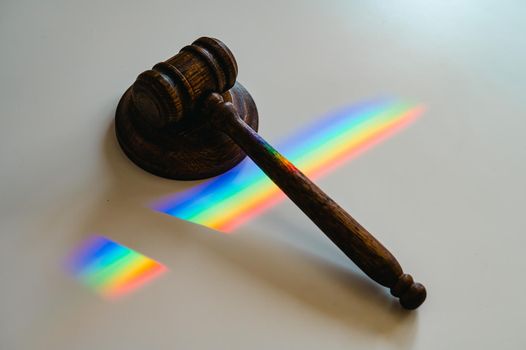 Judicial gavel on a table with a rainbow light prism