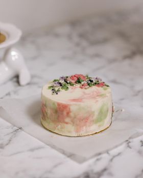 Small bento cake decorated by sugar flowers as a gift for the holiday. Cakes in a box for one person.