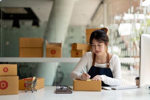 Startup SME small business entrepreneur of freelance asian woman using a laptop with box