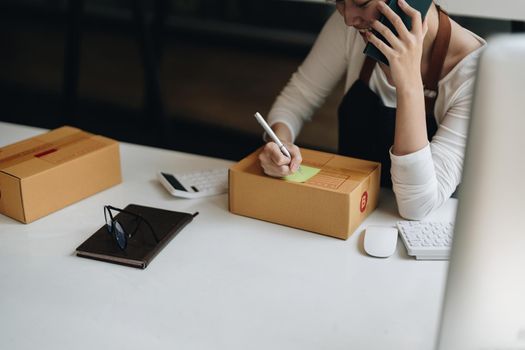 Start up successful small business owner, working from home with laptop computer and online purchase shopping order and box packaging on table.