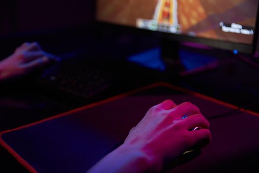 Professional gamer play computer video game in dark room, use neon colored rgb mechanical keyboard, place for cybersport gaming