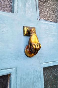 An old mechanical doorbell in the form of a hand