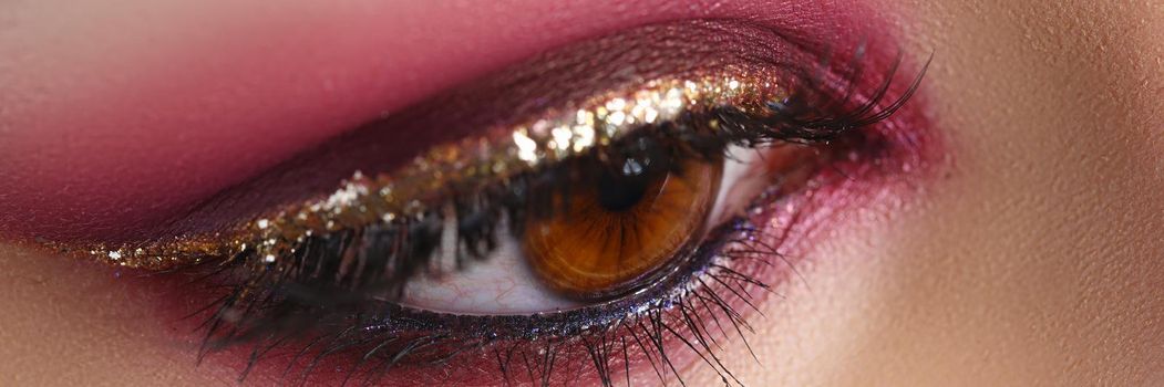 Closeup of female eye with bright pink makeup. Professional make up concept