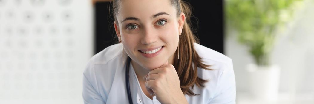 Portrait of smiling woman ophthalmologist in office of clinic. Vision test concept
