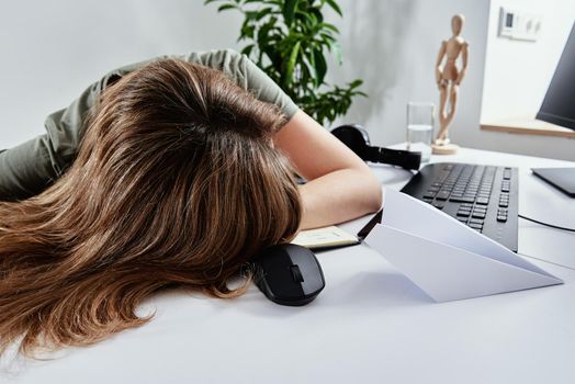 Tired woman sleeps while remotely working at home, overwork burnout, freelancer works remote at home workplace