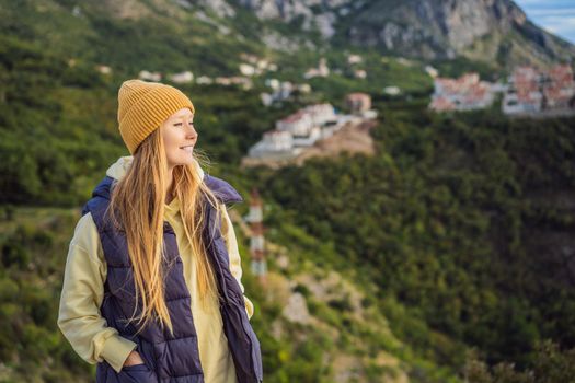 Woman in the mountains of Montenegro in warm clothes. Travel to Montenegro in spring, autumn, winter.