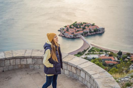 Woman tourist on background of beautiful view of the island of St. Stephen, Sveti Stefan on the Budva Riviera, Budva, Montenegro. Travel to Montenegro concept.