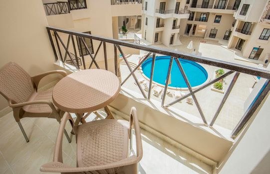 Terrace furniture of a luxury apartment in tropical resort with furniture and pool view from balcony