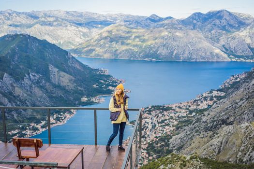 Woman tourist enjoys the view of Kotor. Montenegro. Bay of Kotor, Gulf of Kotor, Boka Kotorska and walled old city. Travel to Montenegro conceptFortifications of Kotor is on UNESCO World Heritage List since 1979.