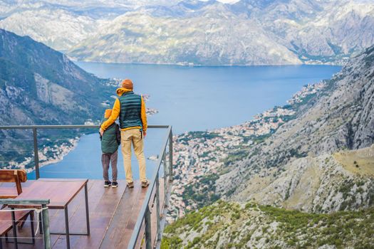 Dad and son travellers enjoys the view of Kotor. Montenegro. Bay of Kotor, Gulf of Kotor, Boka Kotorska and walled old city. Travel with kids to Montenegro concept. Fortifications of Kotor is on UNESCO World Heritage List since 1979.