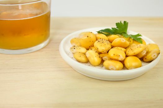 Typical Spanish Tapa of Lupin beans next to cold beer on wooden table