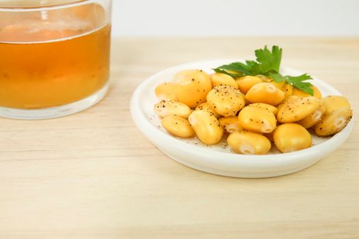 Typical Spanish Tapa of Lupin beans next to cold beer on wooden table