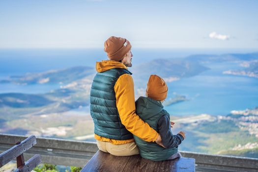 Dad and son travellers enjoys the view of Kotor. Montenegro. Bay of Kotor, Gulf of Kotor, Boka Kotorska and walled old city. Travel with kids to Montenegro concept. Fortifications of Kotor is on UNESCO World Heritage List since 1979.