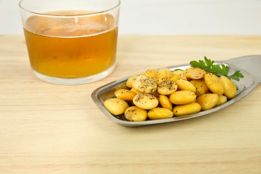 Typical Spanish Tapa of Lupin beans next to cold beer on wooden table