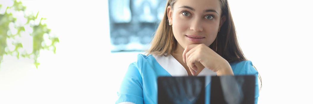 Doctor traumatologist holding xray of hand in clinic. X ray diagnosis of fractures concept