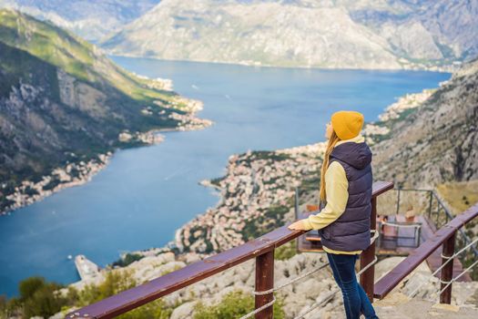 Woman tourist enjoys the view of Kotor. Montenegro. Bay of Kotor, Gulf of Kotor, Boka Kotorska and walled old city. Travel to Montenegro conceptFortifications of Kotor is on UNESCO World Heritage List since 1979.