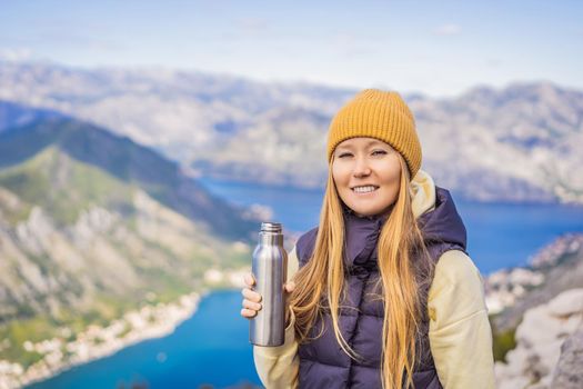 Woman tourist enjoys the view of Kotor. Montenegro. Bay of Kotor, Gulf of Kotor, Boka Kotorska and walled old city. Travel to Montenegro conceptFortifications of Kotor is on UNESCO World Heritage List since 1979.