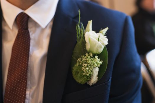 Groom with a boutonniere of white eustoma