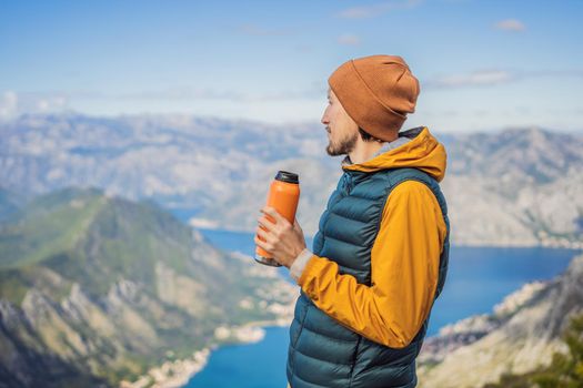 Man tourist enjoys the view of Kotor. Montenegro. Bay of Kotor, Gulf of Kotor, Boka Kotorska and walled old city. Travel to Montenegro concept. Fortifications of Kotor is on UNESCO World Heritage List since 1979.