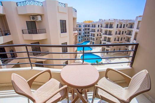 Terrace furniture of a luxury apartment in tropical resort with furniture and pool view from balcony