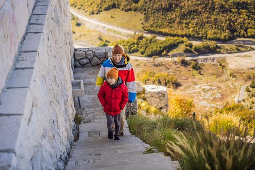 Dad and son travellers in mountain landscape at national park Lovcen, Montenegro. Travel to Montenegro with children concept.