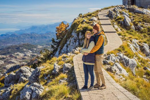 Couple man and woman tourists in mountain landscape at national park Lovcen, Montenegro. Travel to Montenegro concept.