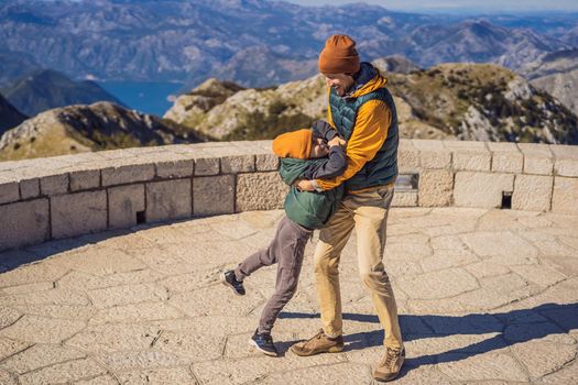 Dad and son travellers in mountain landscape at national park Lovcen, Montenegro. Travel to Montenegro with children concept.