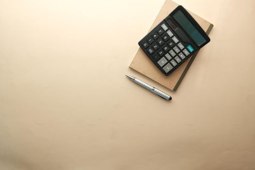 top view of calculator and notepad on color background .