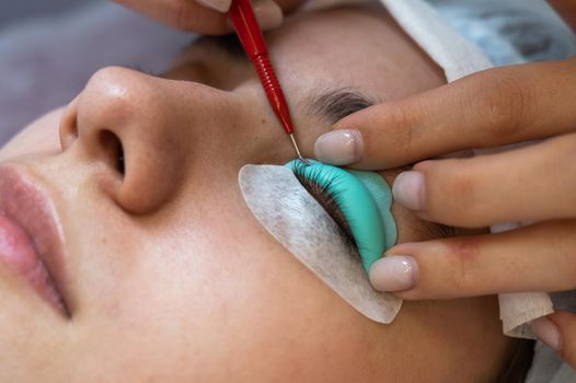 Young woman undergoing eyelash tinting and lamination procedure