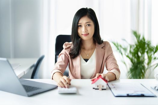 Entrepreneurs, business owners, accountants, real estate agents, Portrait of asian woman uses a calculator to calculate her home budget to assess the risks of investing in real estate