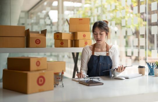 Startup SME small business entrepreneur of freelance asian woman using a laptop with box